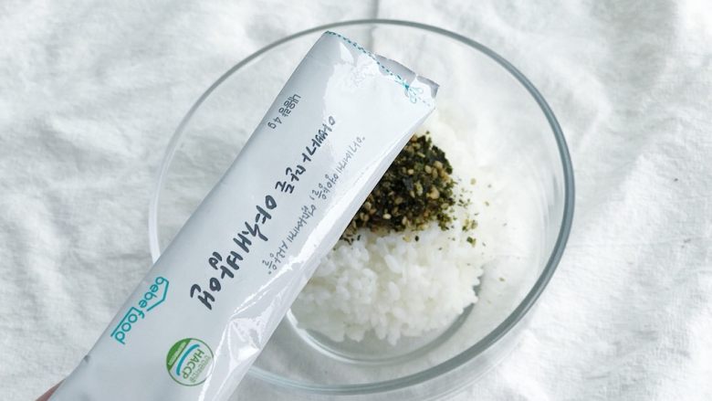 春意盎然之西兰花海苔饭团,倒入1包拌饭海苔(没有的话可以直接用海苔和熟白芝麻)