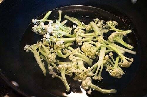 香肠炒花菜,锅里加水连同花菜一起煮熟后捞出沥干备用