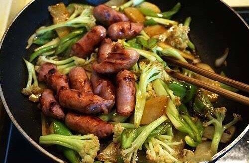香肠炒花菜,待均匀翻炒调味后,将香肠倒入锅中。翻炒