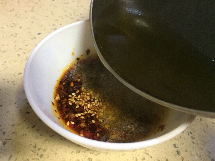巴渝味凉拌猪舌,将烧至8层的油倒入碗里