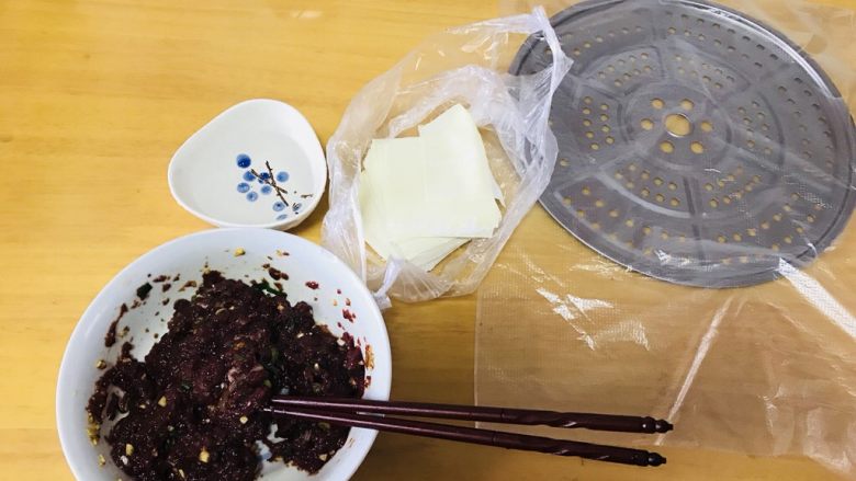 牛肉抄手,把切好的牛肉倒入碗内，根据自己口味加入香料，拌均匀，准备好抄手皮，跟一碗清水