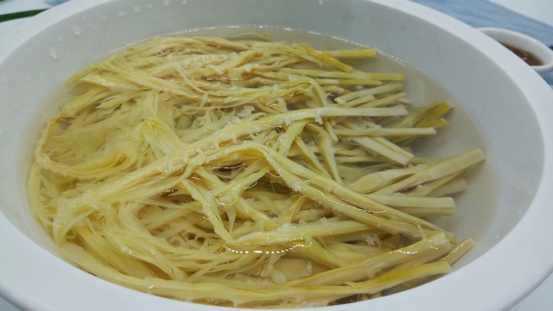 麻香凉拌羊尾笋,撕好的羊尾笋放一个大盘里,加适量的清水泡发,中途可以换一下水,换到咸淡刚好就可以,所以想吃的必须提前泡水,不然太咸没有办法下口的