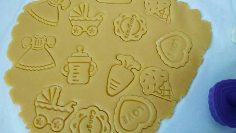 糖霜饼干,剩余的面团放在油纸上,盖上保鲜膜擀成3mm的面片,用饼干模具压出各种形状,去除多余的面片,连同油纸放入烤盘。(这样饼干就不会因移动而变形)