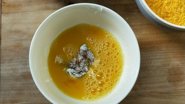 油炸劲辣香酥鸡米花,放入鸡蛋液中浸泡一下,筷子夹起,让蛋液不流淌下来。