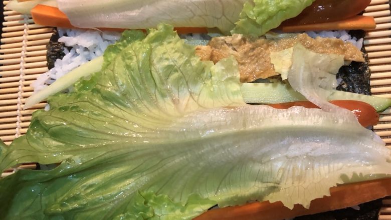 鸡蛋胡萝卜火腿寿司,按紫菜，米饭，青菜，肉，最后生菜铺好