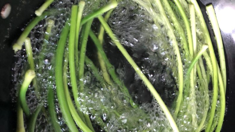 凉拌蒜苔,锅里放水加一点盐煮开,放入蒜苔焯水2分钟。