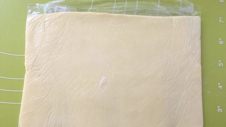 起酥小面包,之后对折保鲜袋,用擀面杖将黄油擀均匀,入冰箱冻硬