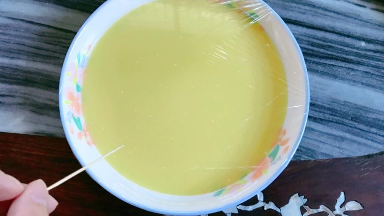 肉末蒸蛋,盖上保鲜膜,用牙签刺些孔。防蒸汽下滴。