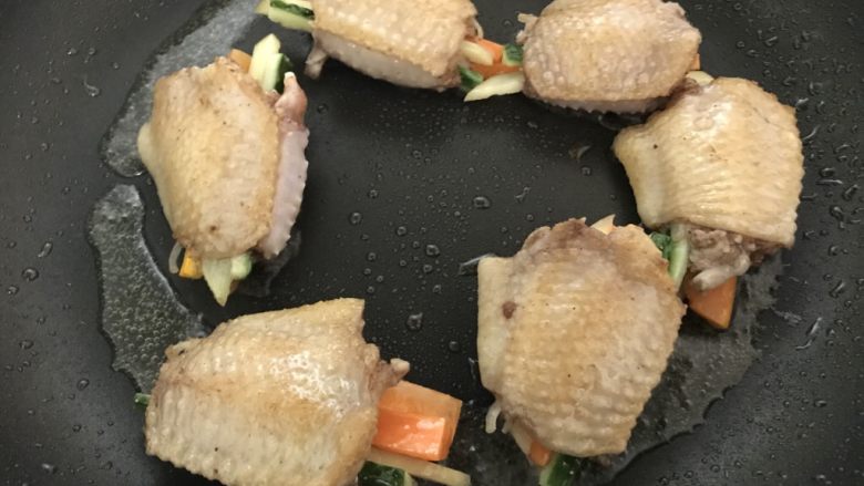 鸡翅换个花样做,时蔬酿鸡翅,煎至变色后,翻转另一面。