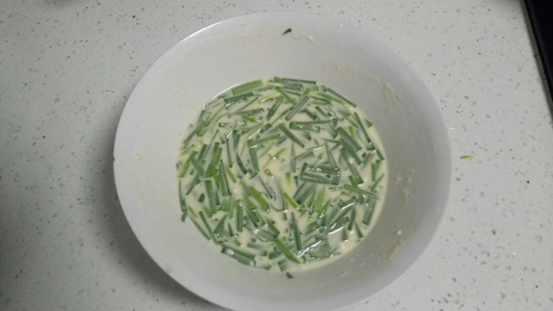韭菜鸡蛋煎饼,将韭菜放入面汁中搅拌均匀。