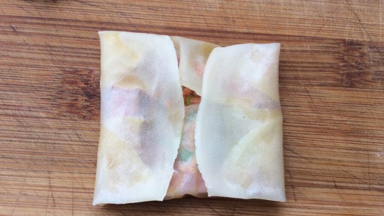 饺子皮版—火腿胡萝卜鸡蛋饼,前后两边对折后，在左右两边边对折，用手轻轻压一下让蛋液粘合在一起