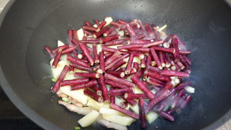 紫豆角烧土豆条,加入豆角、土豆条、<a style='color:red;display:inline-block;' href='/shicai/ 718'>料酒</a>翻炒1分钟