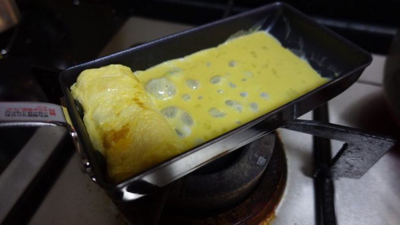 日式厚蛋烧,待蛋液半凝固卷起来,倒入第二层鸡蛋液。