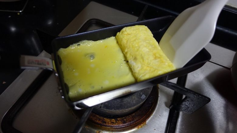 日式厚蛋烧,借助刮刀卷起来的时候,边卷边用刮刀靠住厚蛋烧,尽量形成一个长方体。