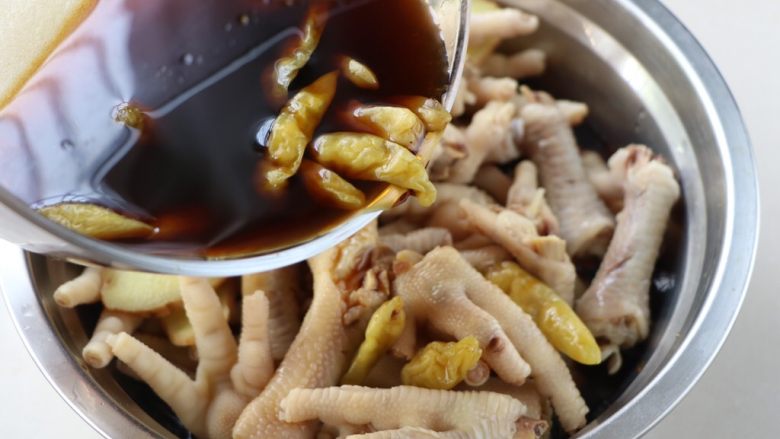 网红柠檬凤爪,倒入鸡爪里,丢2片生姜进去;酱汁正好可以没过鸡爪为宜;