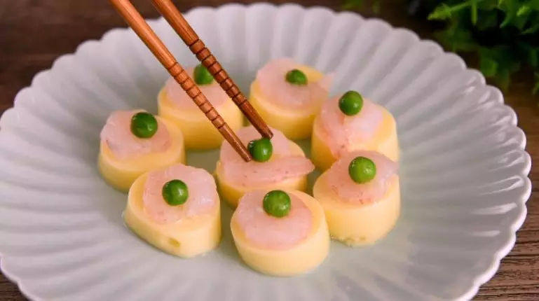 日本豆腐质地嫩滑,加上虾仁的鲜香口感,简直就是完美的搭配!,每块豆腐上放一个虾仁、一粒青豆
