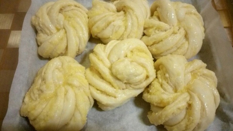 椰蓉小餐包,放入烤箱进行二次发酵,烤盘下边放杯开水,保温又保湿,二次发酵完成后,刷蛋液,放入预热好的烤箱180度,中层,烤30分钟