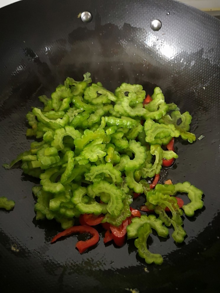 苦瓜炒蛋,锅里倒油，下红椒、苦瓜爆炒
