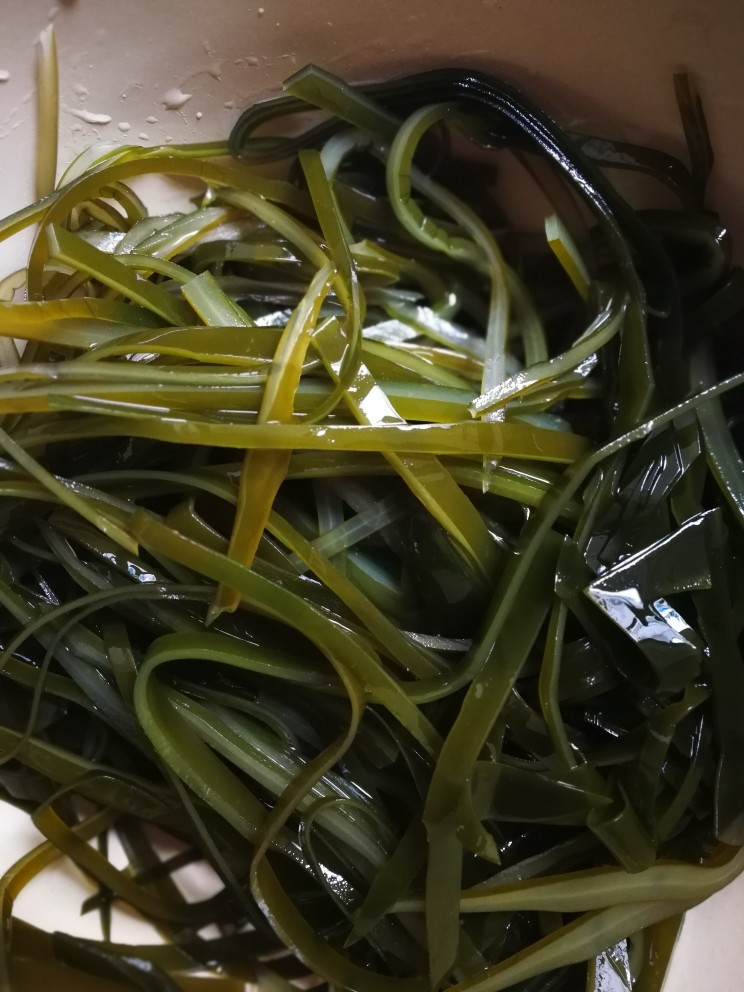 开胃凉拌海带丝,捞出焯过水的海带,用冷水洗干净后,再切成丝