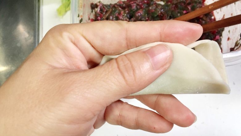 电饭锅版无油煎饺的包法,接下来就是包饺子,现料放在<a style='color:red;display:inline-block;' href='/shicai/ 4346'>饺子皮</a>当中,中间捏一下
