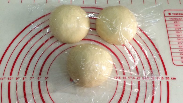 炼乳吐司(中种法),发好的面团取出排气,平均分成三份,滚圆松弛15分钟。