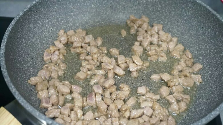 秘制千刀肉,炒锅放适量油,油5成热,将肉丁下入锅里划散,然后转大火,肉变色即可。