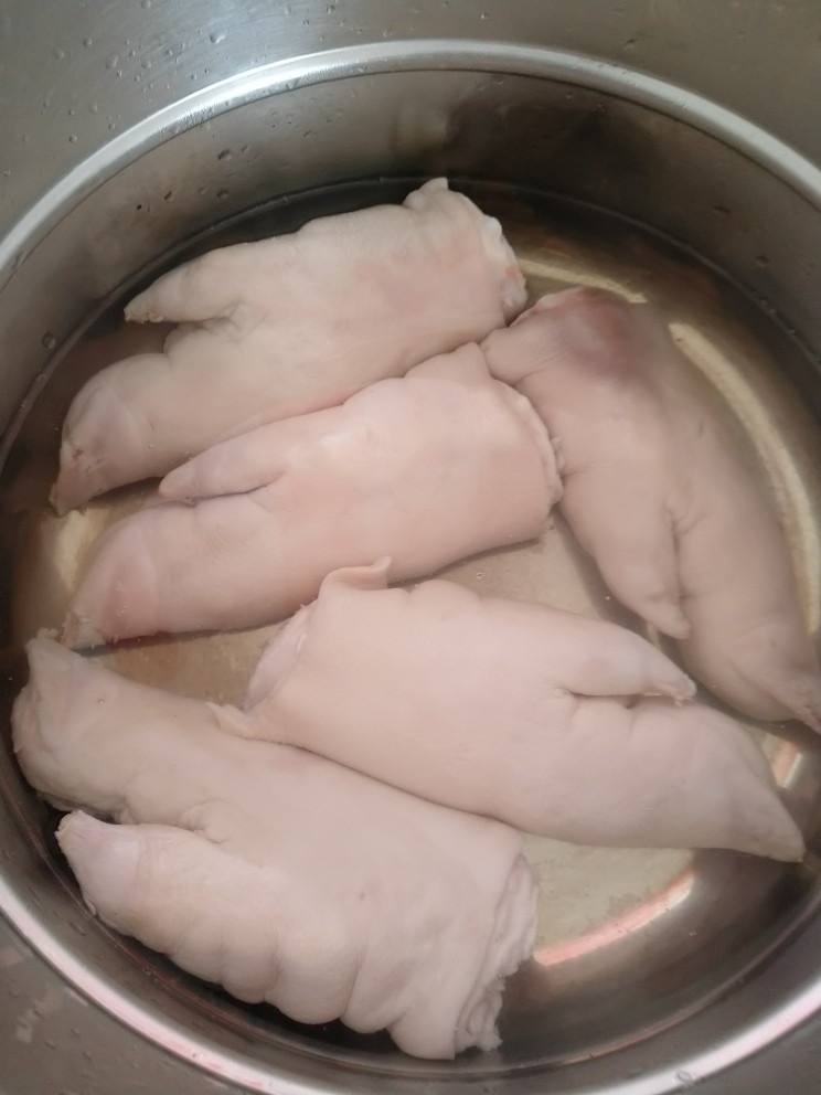 家庭版简易红烧猪蹄,凉水提前浸泡半个或一个小时 开火起锅烧热水 待水煮沸后放入提前处理好的猪蹄 撇去表面浮沫 这样可以去除猪蹄里的血迹 5分钟后捞出沥干水分备用
