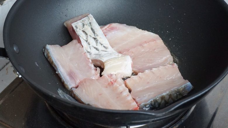 豆角焖鱼,炒锅里加油,烧热后,鱼放入。