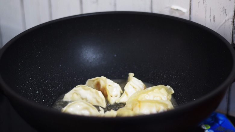 抱蛋煎饺,加入清水,只要饺子的二分之一高,盖上锅盖焖至饺子变成透明
