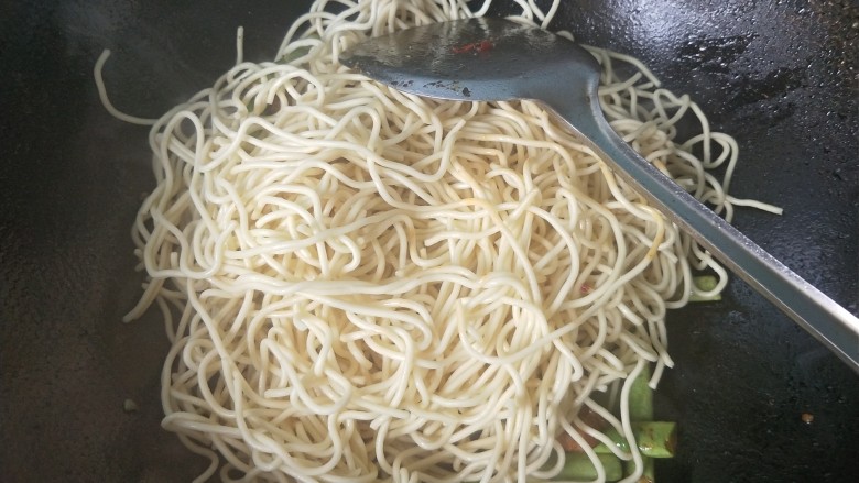 豆角五花肉焖面,四季豆熟了以后,放入面条,放入小半碗清水,盖上锅盖再焖一会。