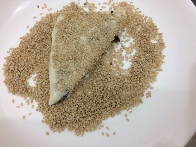 紫菜芝麻饼,放入盘中,均匀的沾上芝麻