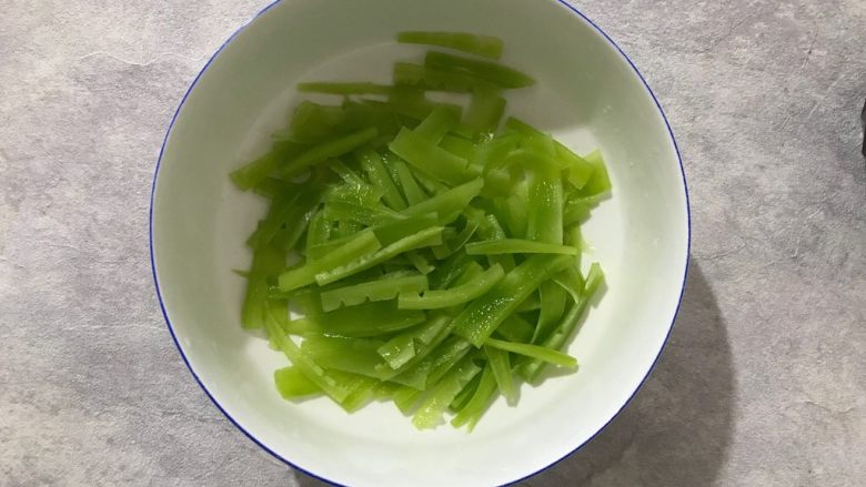 芥末莴笋拌木耳,双手捧着碗,上下颠十几下,让细盐和莴笋充分混合,然后静置15分钟