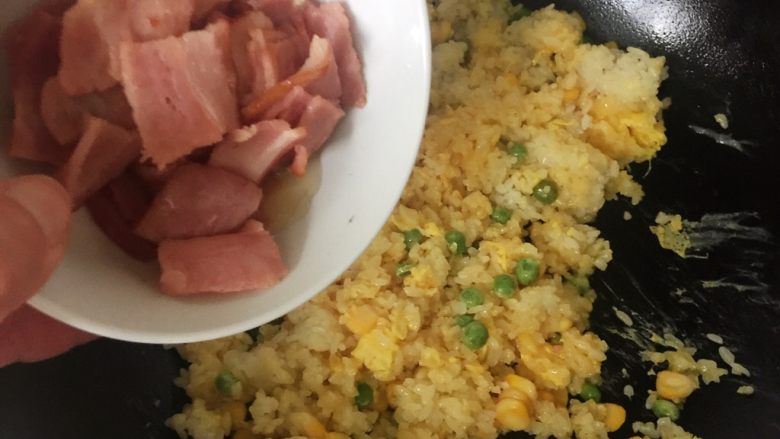 菠萝培根炒饭,倒入培根,加适量的盐后,同样也快速翻炒