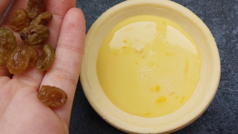 葡萄干蛋挞,然后把做好的蛋挞水,倒入蛋挞皮中,八分满就可以,再加几粒<a style='color:red;display:inline-block;' href='/shicai/ 603'>葡萄干</a>