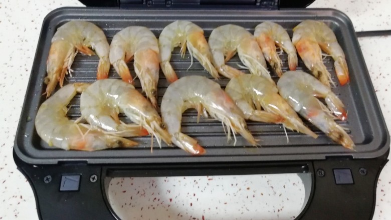香煎厄瓜多尔白虾,码入腌好的白虾,盖上盖子煎5分钟。
