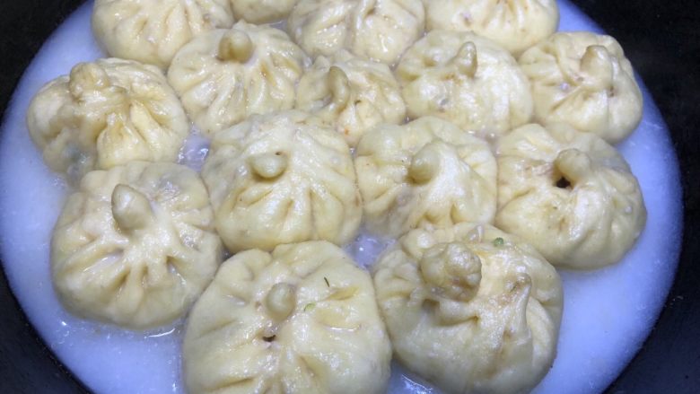 豆角猪肉生煎包,玉米淀粉和水1:1混合好,当锅中水差不多烧干之后,将淀粉水倒入,水量要多,差不多到达包子的一半处,盖锅盖继续煎。