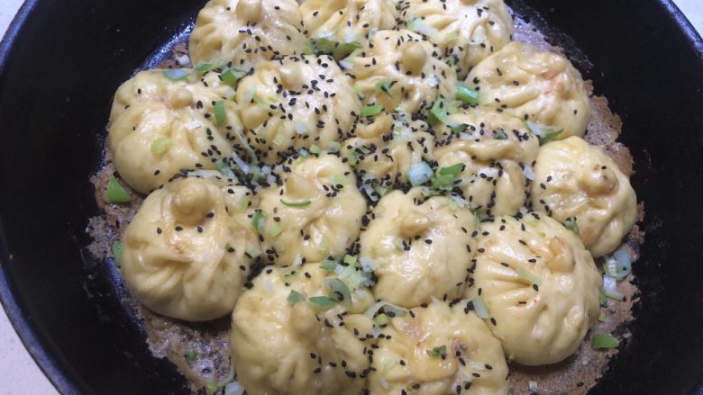 豆角猪肉生煎包,撒上葱花和黑芝麻,再盖上锅盖焖1分钟
