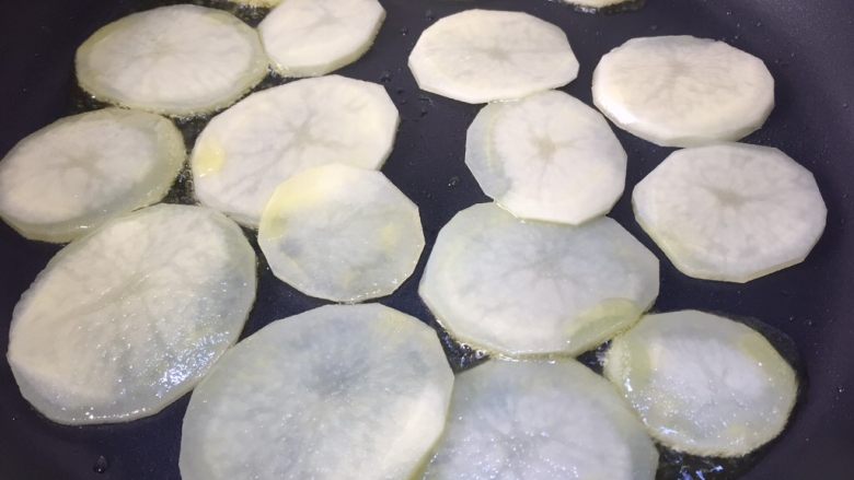 广式腊肠炒土豆,不粘锅内放少许油,放入土豆片煎