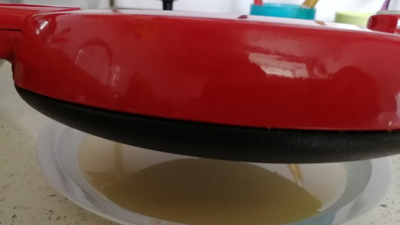 薄饼&东北四样吃薄饼,博饼锅插上电源烧热,翻过来粘上面糊(如图)。