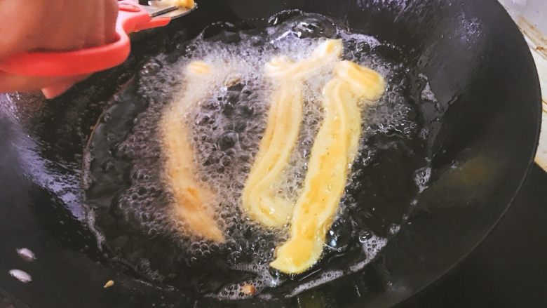 吉事果🥓,将油烧热,将面糊挤进去,我们可以用剪刀剪断,剪出适合的长度