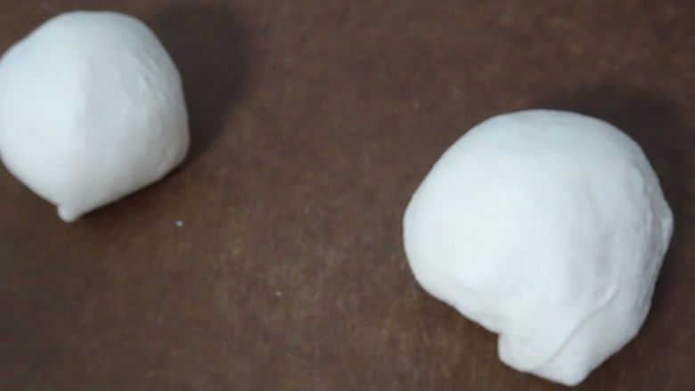 拿坡里起司巧克力炸披薩(2個),將麵糰平分成2塊,每塊約150g分別滾圓。滾圓時用手掌控制住麵糰,手指手掌稍微用點力道朝下方施壓,往自己的方向滾,讓麵團稍微緊實;期望麵團表面光滑、形狀勻稱,讓麵團的收口朝下。