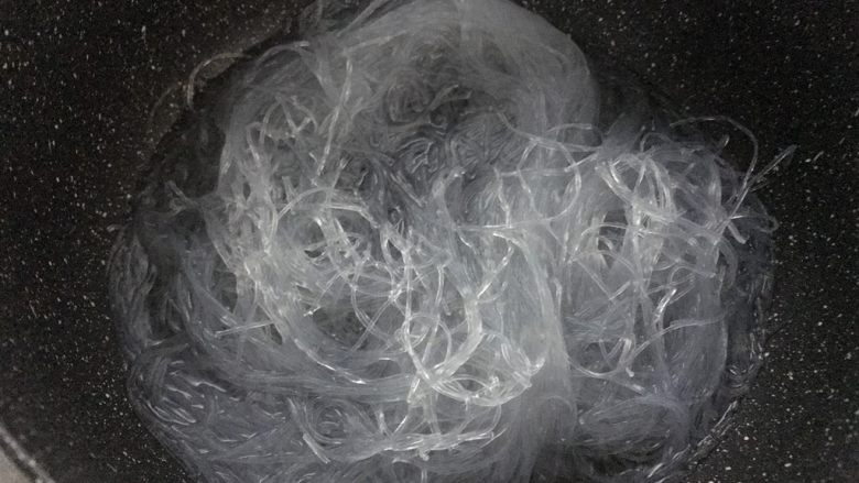 蒜蓉粉丝蒸扇贝,锅里烧开水后关火,把粉丝泡入,泡软了,捞出沥水。