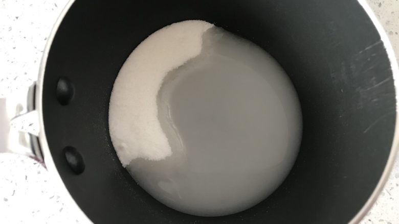 小粉马,把细砂糖2倒入奶锅中,加入矿泉水1,用筷子把细砂糖和水搅拌均匀。奶锅大家尽量选择口径小的,我这个是12厘米口径的,不要选择12厘米以上的,太大口径的熬糖水容易糊底。