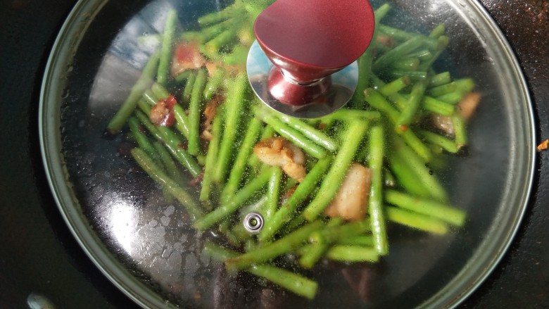 干煸豆角,盖上锅盖,小火焖一会。