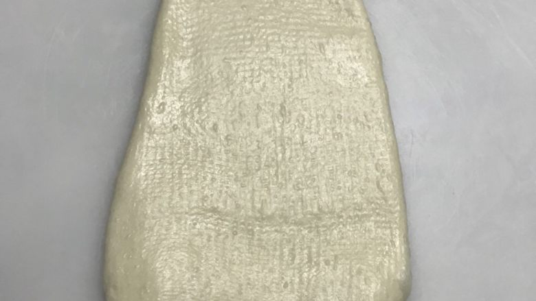 简单牛奶吐司,擀开成长椭圆形。