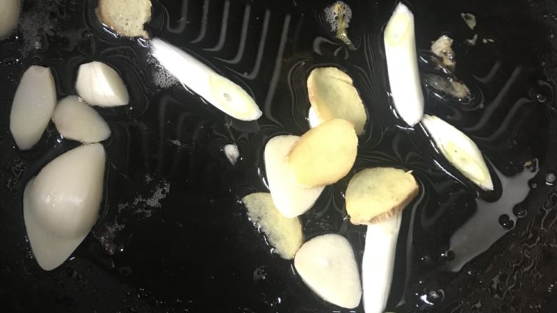 干锅土豆片,另一个锅中倒入食用油,放入辣椒段,蒜片,姜片煸炒