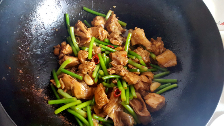 ~蒜苗炒鸡块,随后放点盐,翻炒两分钟。