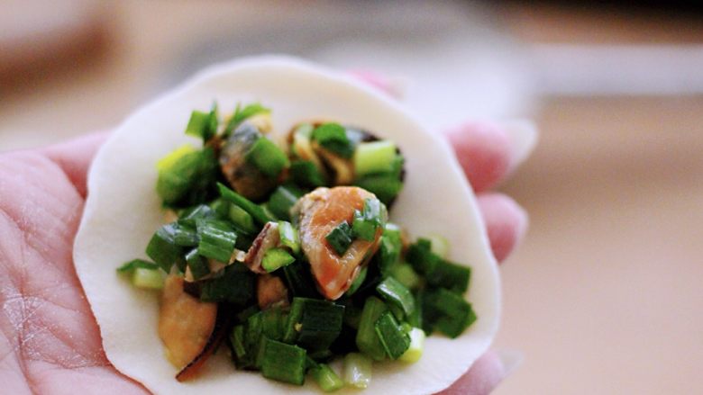 韭菜海虹馅饼(烟台特色),把擀好的面皮上放入适量搅拌好的馅料