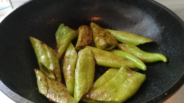 油焖青辣椒,继续煎,煎至上色,变软(如图)