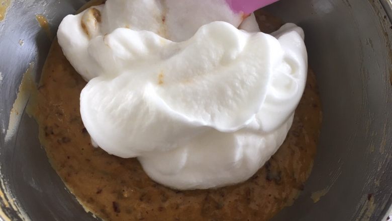 老少咸宜的红枣戚风蛋糕,取1/3蛋白霜与蛋黄面糊翻拌均匀后,再把翻拌好的混合面糊倒入到剩余的蛋白霜里翻拌均匀。